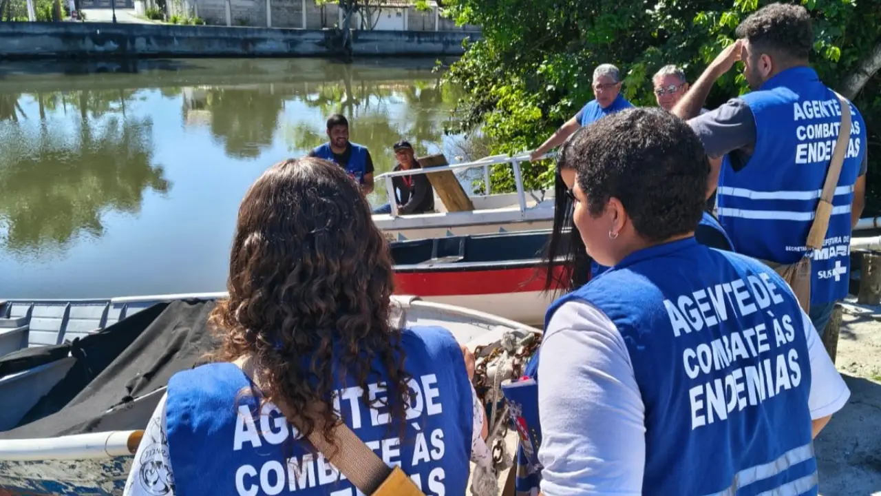 Agente de endemias vistoria recipiente em área próxima à orla de Bambuí, em Maricá