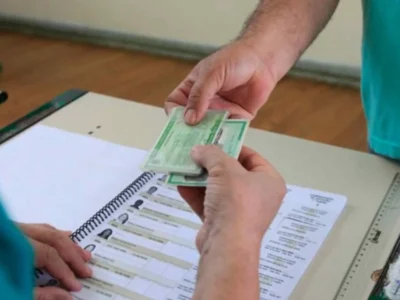 Eleitor apresenta documento ao mesário antes de votar nas Eleições 2026