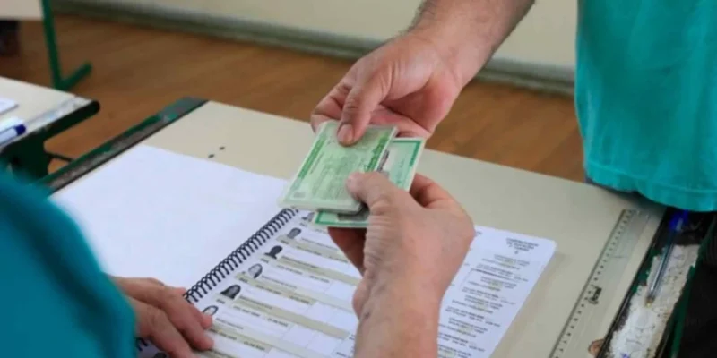 Eleitor apresenta documento ao mesário antes de votar nas Eleições 2026