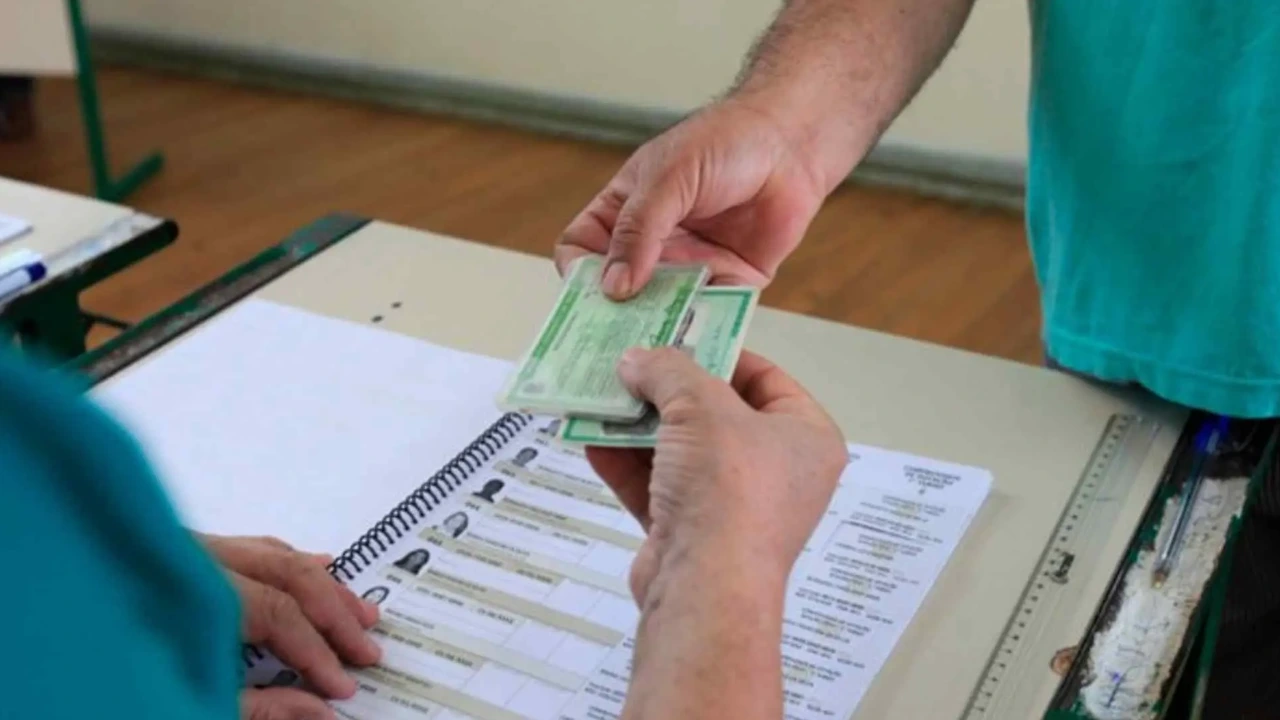 Eleitor apresenta documento ao mesário antes de votar nas Eleições 2026