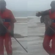 Gari segura cachorro após resgate durante ressaca na Praia de Copacabana
