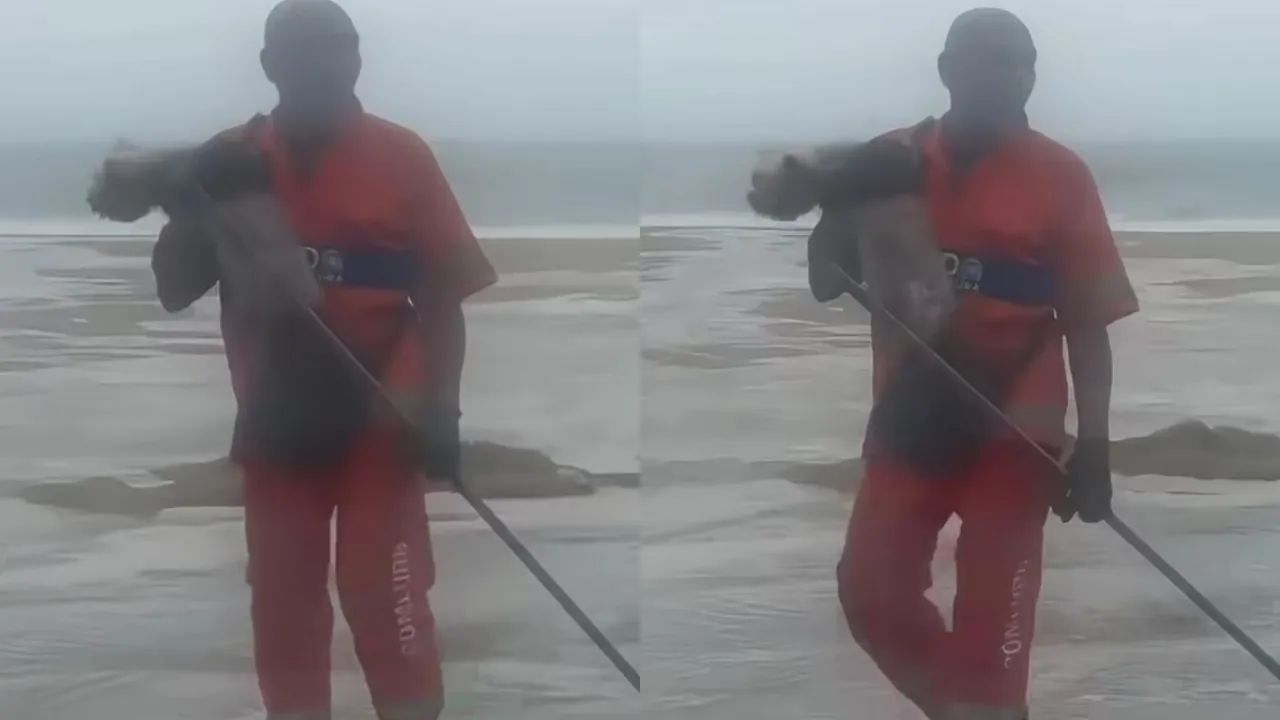 Gari segura cachorro após resgate durante ressaca na Praia de Copacabana Gari segura cachorro após resgate durante ressaca na Praia de Copacabana
