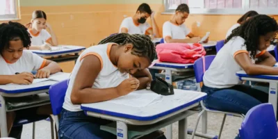 Estudante da rede municipal de Niterói sentado em sala de aula diante de caderno aberto