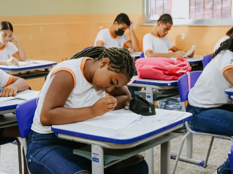 Estudante da rede municipal de Niterói sentado em sala de aula diante de caderno aberto