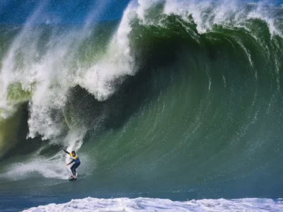 Surfista desliza diante de uma onda grande em imagem de divulgação do Itacoatiara Big Wave 2026