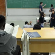 Imagem de uma sala de aula com estudantes e um professor