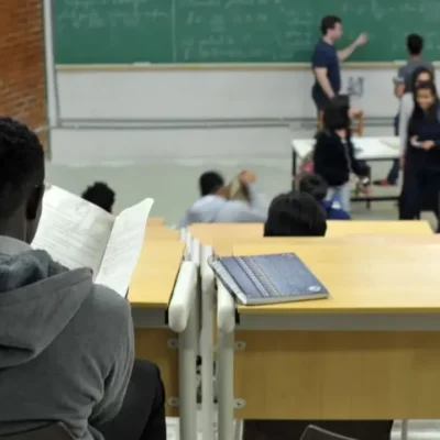 Imagem de uma sala de aula com estudantes e um professor