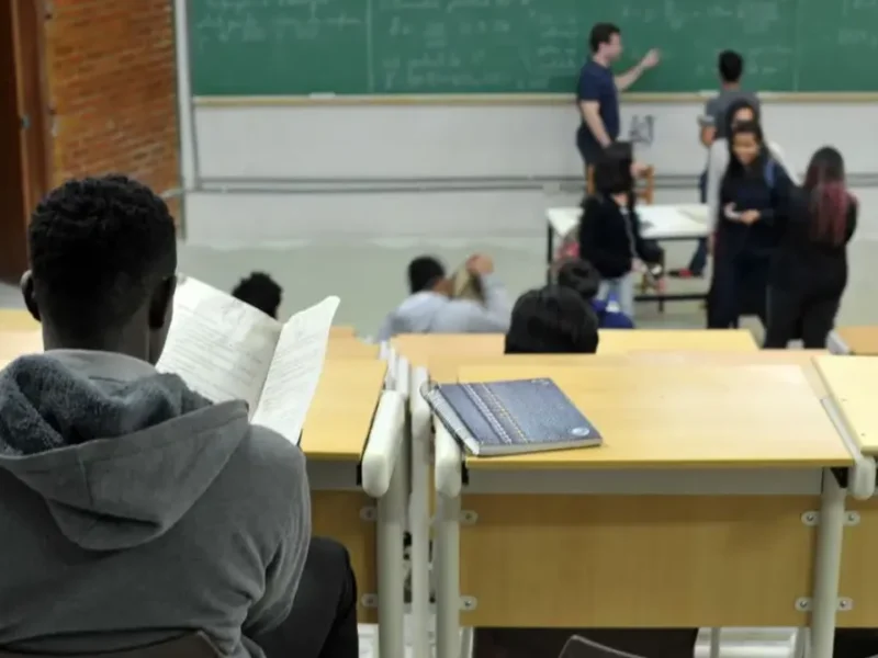 Imagem de uma sala de aula com estudantes e um professor