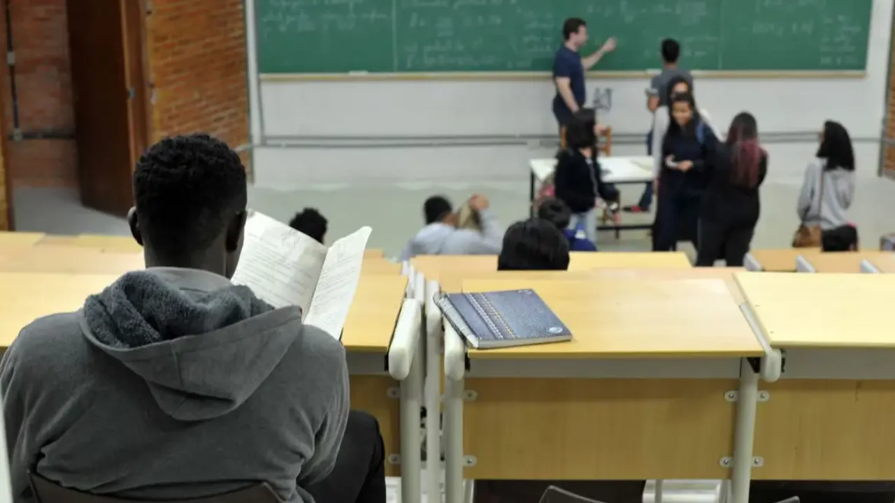 Imagem de uma sala de aula com estudantes e um professor