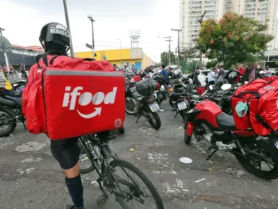 Aplicativos de compras e entregas exibidos em celular ao lado de medicamentos. A Anvisa revogou medidas contra iFood, Rappi, Mercado Livre, Americanas, Submarino e Shopee, enquanto prepara a regulamentação da Lei 15.357/2026 para o uso de plataformas digitais por farmácias e drogarias