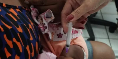 Profissional de saúde aplica vacina em criança durante campanha de multivacinação em São Gonçalo