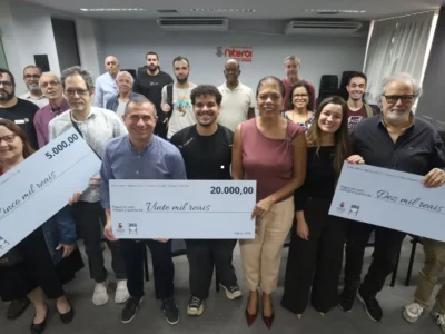 Ganhadores do NitNota Cidadã seguram cheques simbólicos durante premiação em Niterói