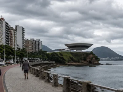 Imagem jornalística sobre a previsão do tempo em Niterói nesta terça-feira, marcada por temperaturas amenas, grande nebulosidade e pouca chuva prevista