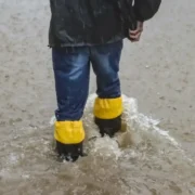 Pessoa caminha por rua alagada durante chuva forte no Rio Grande do Sul