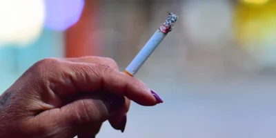Pessoa segura cigarro apagado em reportagem sobre tratamento gratuito para parar de fumar em Niterói