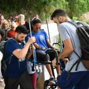 Imagem de pessoas ajudando uma pessoa com deficiência durante trilha em Niterói