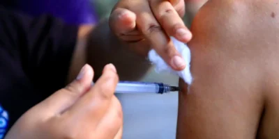 Criança segura caderneta de vacinação em unidade de saúde de Niterói