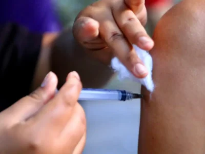 Criança segura caderneta de vacinação em unidade de saúde de Niterói