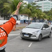 Agente da NitTrans sinaliza o trânsito enquanto veículos circulam por via de Niterói