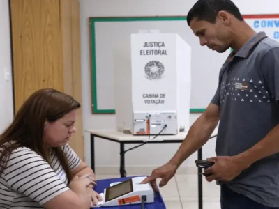 Eleitor é atendido por mesária em seção eleitoral durante votação