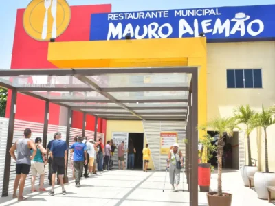 Fachada do Restaurante Municipal Mauro Alemão, em Inoã, Maricá, com usuários na entrada