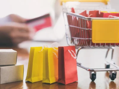 Carrinho de compras, sacolas, caixas e cartão representam compras internacionais pela internet