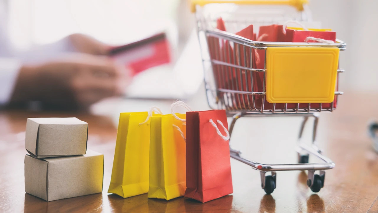 Carrinho de compras, sacolas, caixas e cartão representam compras internacionais pela internet