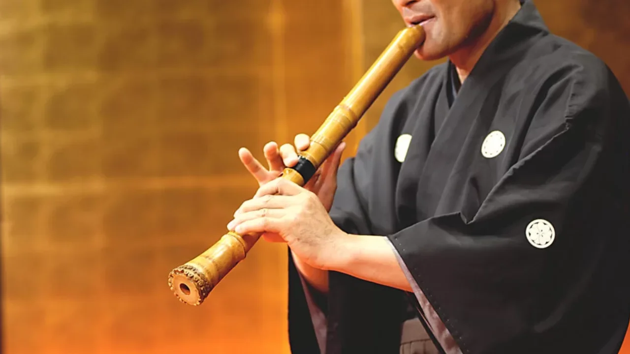 Músico toca shakuhachi, tradicional flauta japonesa de bambu. Músico toca shakuhachi, tradicional flauta japonesa de bambu.