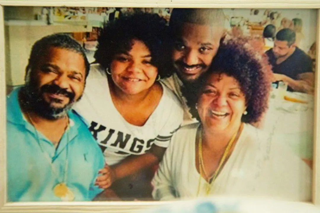 Fotografia de família com quatro pessoas reunidas e sorrindo