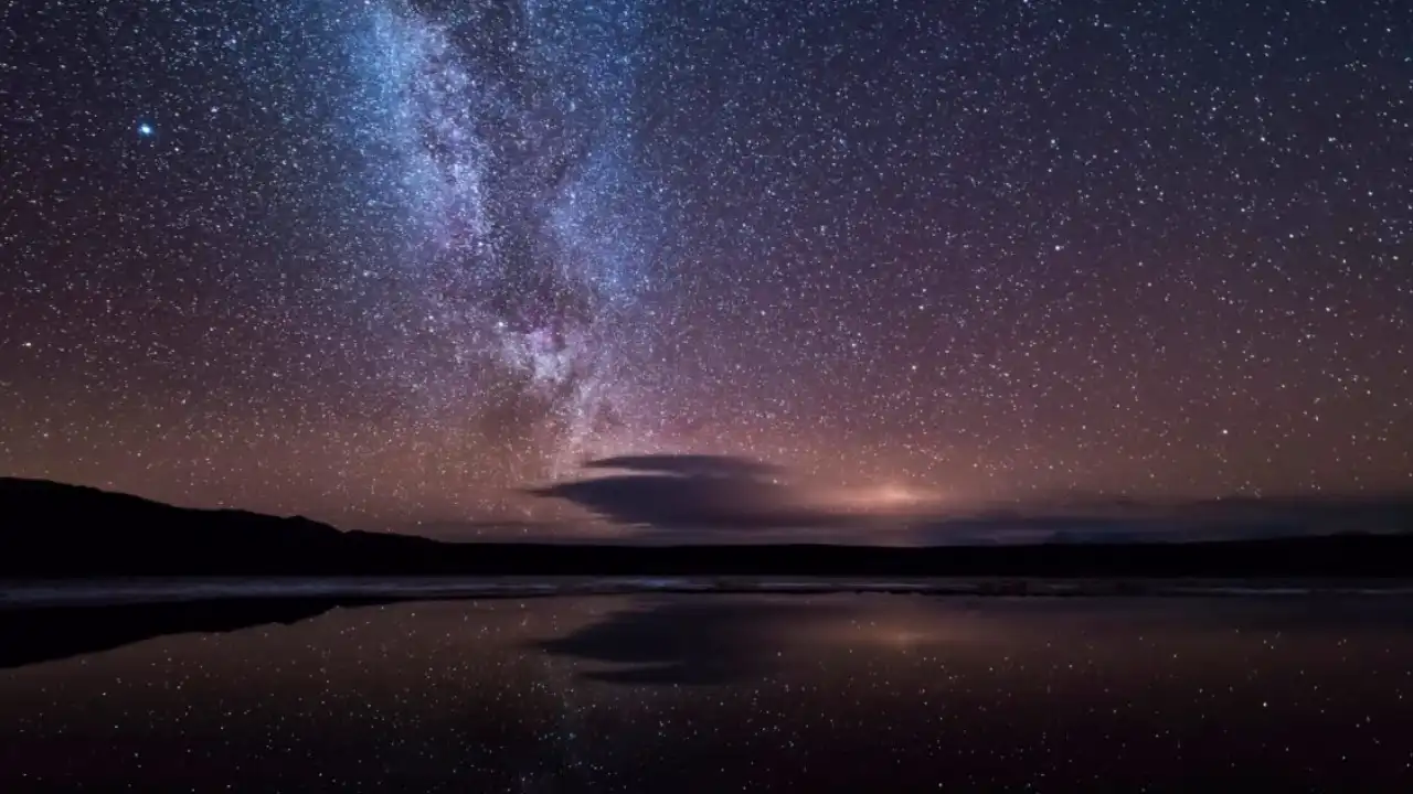 Céu noturno estrelado com a Via Láctea refletida sobre a água Céu noturno estrelado com a Via Láctea refletida sobre a água