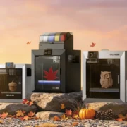 Impressoras 3D da QIDI expostas com peças impressas e rolos de filamento.