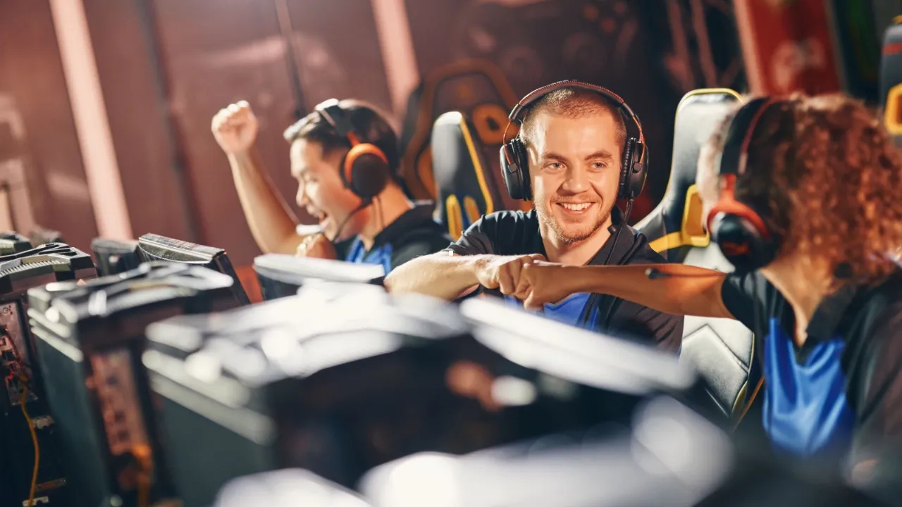 Jogadores com headsets disputam partida de videogame em ambiente de competição Jogadores com headsets disputam partida de videogame em ambiente de competição