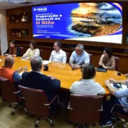 Reunião de equipes municipais de Niterói diante de painel do Plano Municipal de Preparação e Resposta ao El Niño