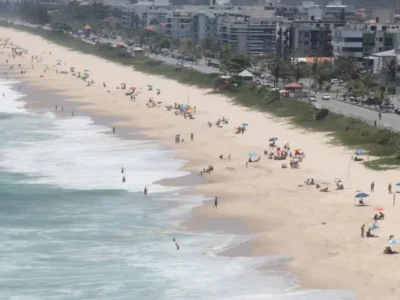 Vista panorâmica de praia de Niterói com faixa de areia, banhistas e ocupação urbana junto à orla