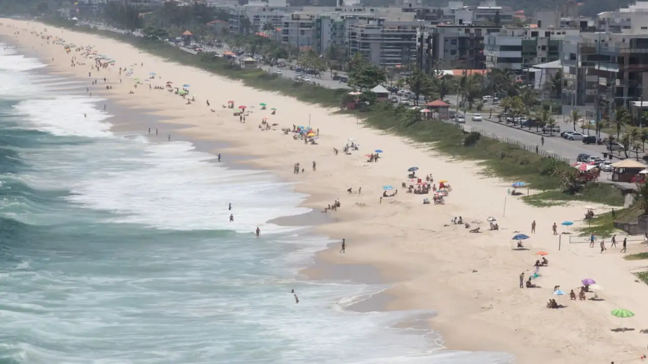 Vista panorâmica de praia de Niterói com faixa de areia, banhistas e ocupação urbana junto à orla