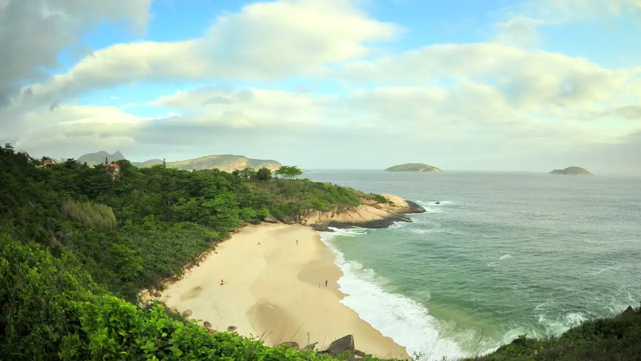 Vista panorâmica da Praia do Sossego, em Niterói, com vegetação preservada, areia, costões e mar Vista panorâmica da Praia do Sossego, em Niterói, com vegetação preservada, areia, costões e mar