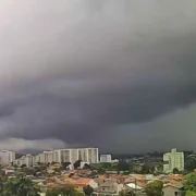 Vista panorâmica de Itaboraí sob forte calor e céu coberto por nuvens cinzentas de tempestade avançando sobre a área urbana