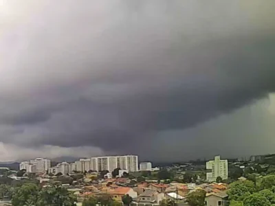 Vista panorâmica de Itaboraí sob forte calor e céu coberto por nuvens cinzentas de tempestade avançando sobre a área urbana