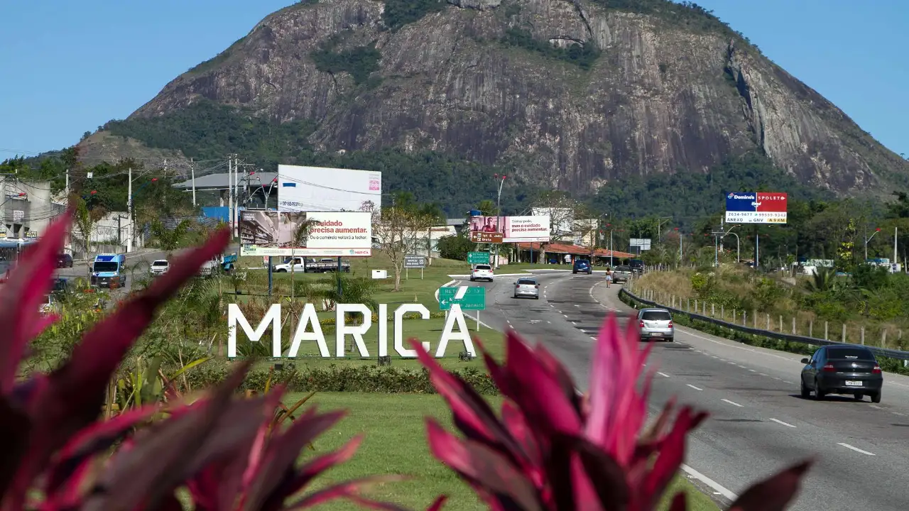 Entrada de Maricá com montanha ao fundo em dia de céu aberto