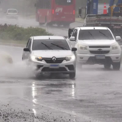 Veículos trafegam sob chuva forte em avenida de Maricá
