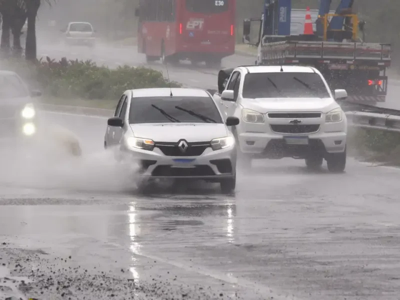Veículos trafegam sob chuva forte em avenida de Maricá