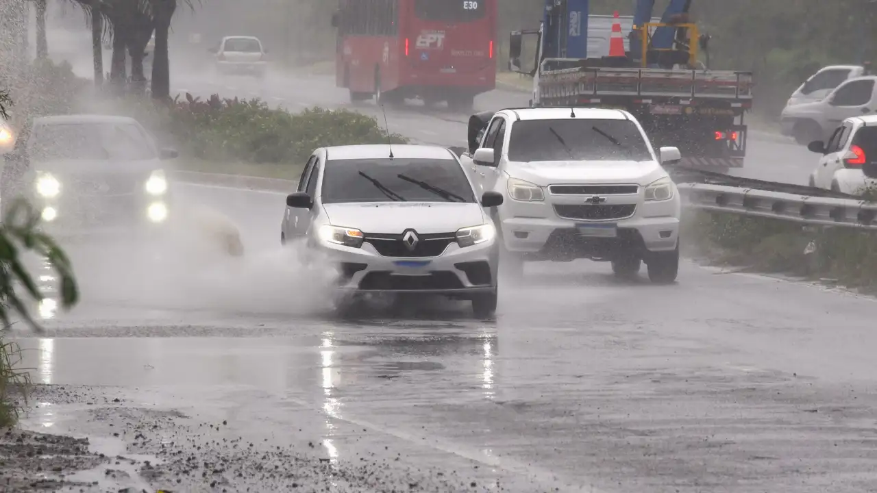 Veículos trafegam sob chuva forte em avenida de Maricá