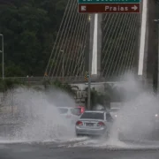 Carros passam por trecho alagado durante chuva no Rio de Janeiro