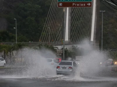 Carros passam por trecho alagado durante chuva no Rio de Janeiro