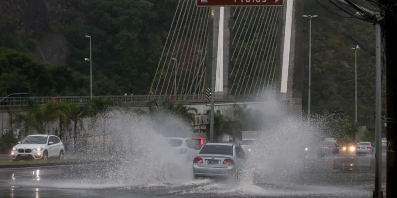 Carros passam por trecho alagado durante chuva no Rio de Janeiro