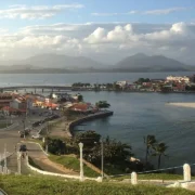 Vista de Saquarema com lagoa, área urbana e nuvens sobre a cidade