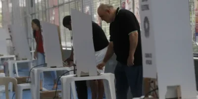 Eleitores chegam a local de votação durante as Eleições 2026 sob regras contra boca de urna e propaganda eleitoral