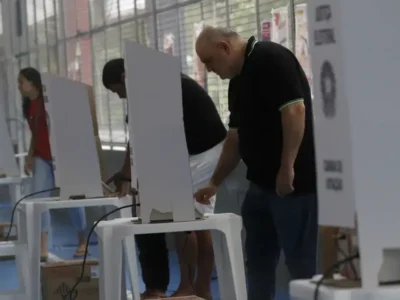 Eleitores chegam a local de votação durante as Eleições 2026 sob regras contra boca de urna e propaganda eleitoral