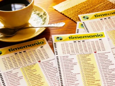 Mesa sobreposta com volantes da lotomania acompanhados de uma xícara com café, pires e colher, para ilustração de reportagem sobre o concurso 2438 da Timemania, com resultado dos números sorteados no domingo, 06/09, bem como prêmios de todas as faixas de acerto. Soma do total de apostas realizadas, e análises econômicas, financeiras e lotéricas tanto sobre as ganhadoras quanto perdedoras, com base na arrecadação.