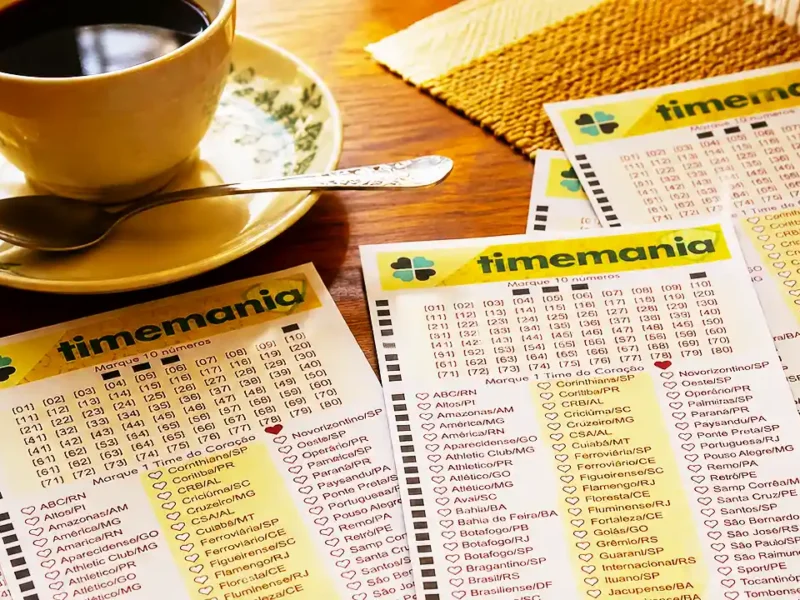 Mesa sobreposta com volantes da lotomania acompanhados de uma xícara com café, pires e colher, para ilustração de reportagem sobre o concurso 2438 da Timemania, com resultado dos números sorteados no domingo, 06/09, bem como prêmios de todas as faixas de acerto. Soma do total de apostas realizadas, e análises econômicas, financeiras e lotéricas tanto sobre as ganhadoras quanto perdedoras, com base na arrecadação.